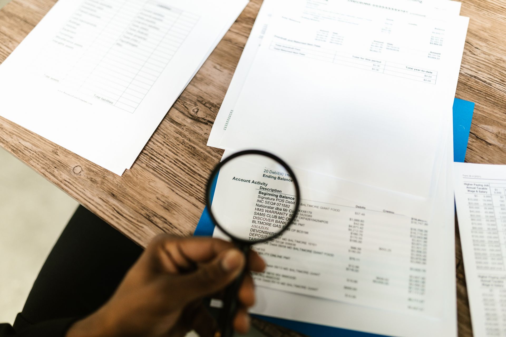 A magnifying glass over documents and contracts